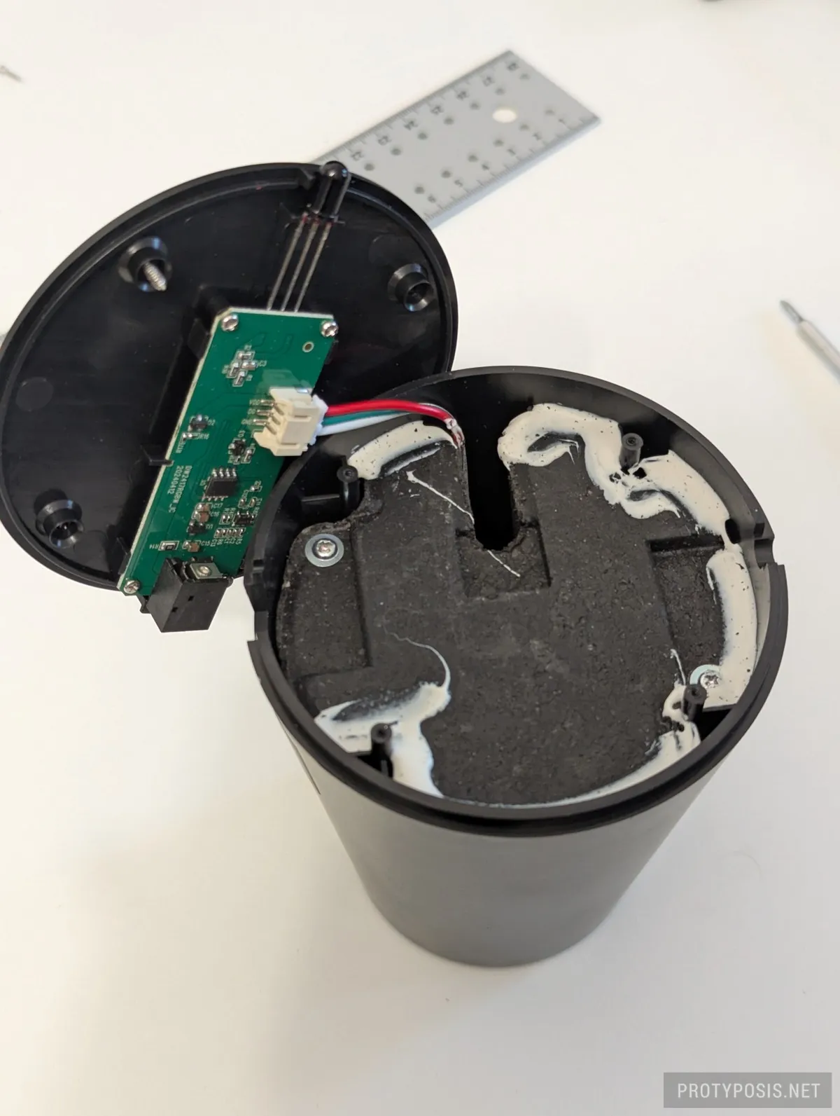 Opened case with controller board, cable to strip socket, and base weight